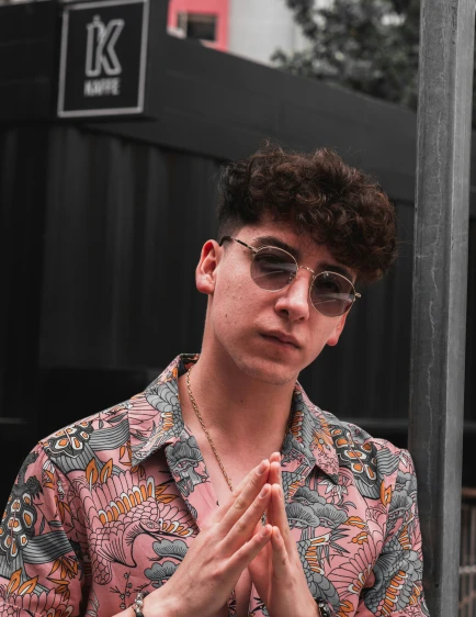 the young man is wearing sunglasses and a peace sign