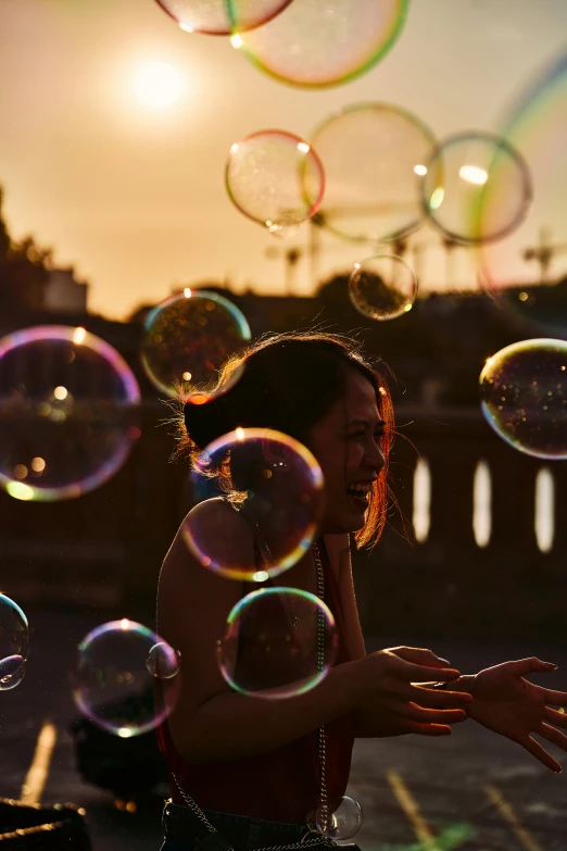 a woman in a black dress blowing soap bubbles