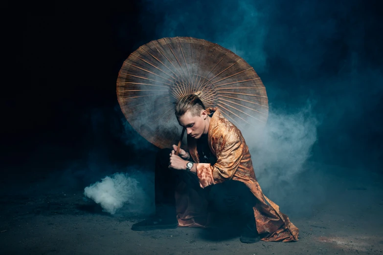 a man in an oriental kimono holding a umbrella in smoke