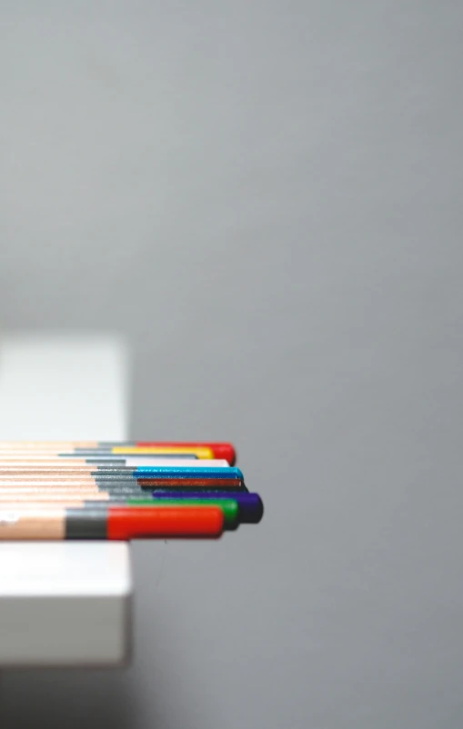 several colored pencils on a table with one in focus