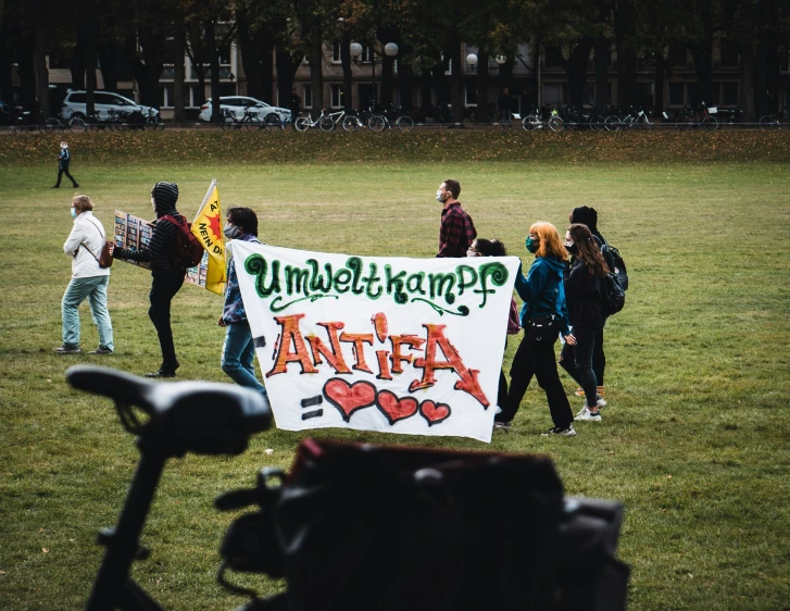 people holding up a protest sign while walking