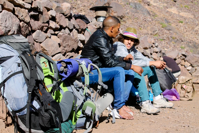 a man and girl sitting on rocks next to a pile of luggage