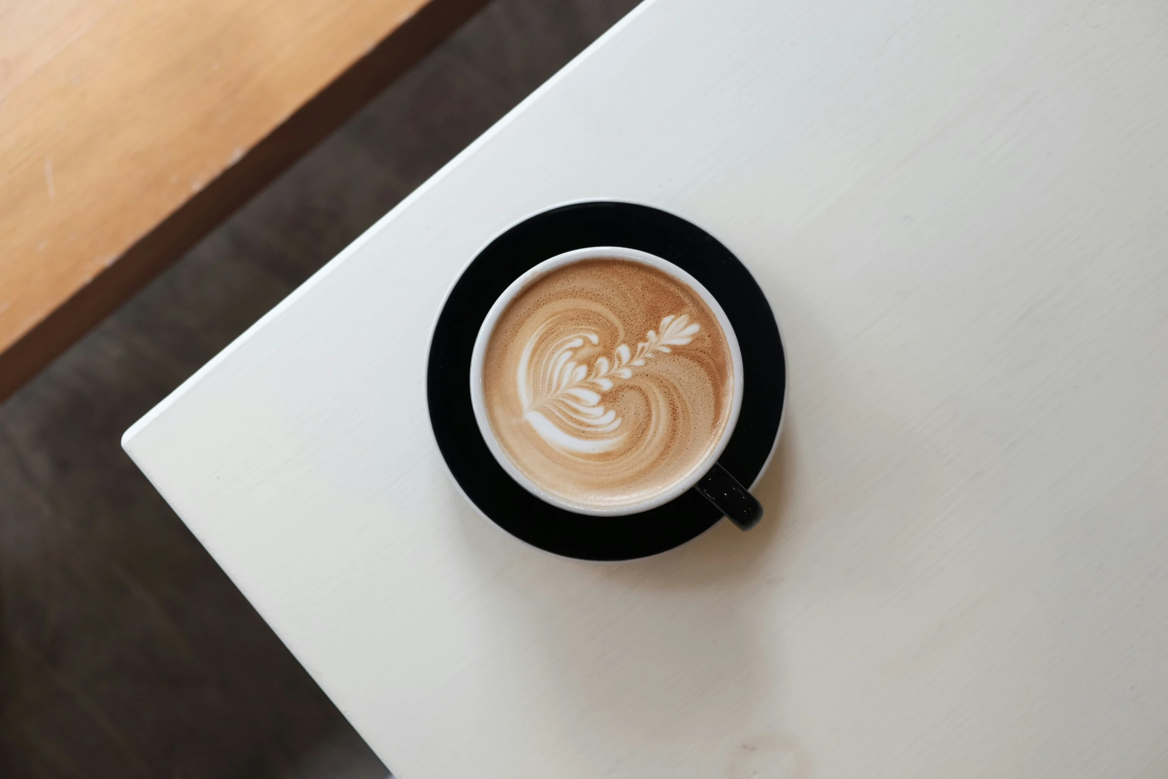 a cappuccino is pographed from above on a small coaster