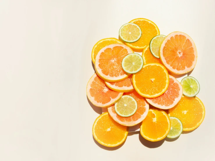 a pile of oranges with slices cut in half