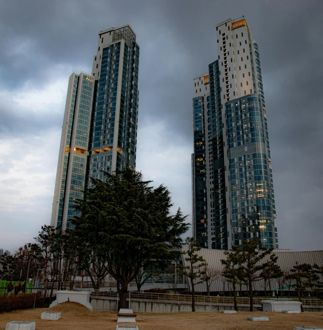 a bunch of very tall buildings against the cloudy sky