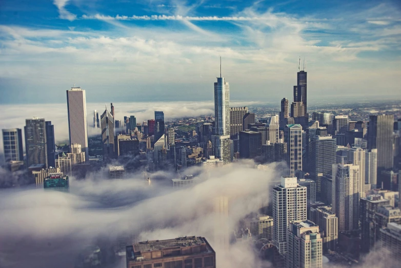 a city skyline in the middle of some clouds