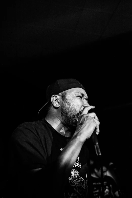 a man on stage singing with his hands in his mouth