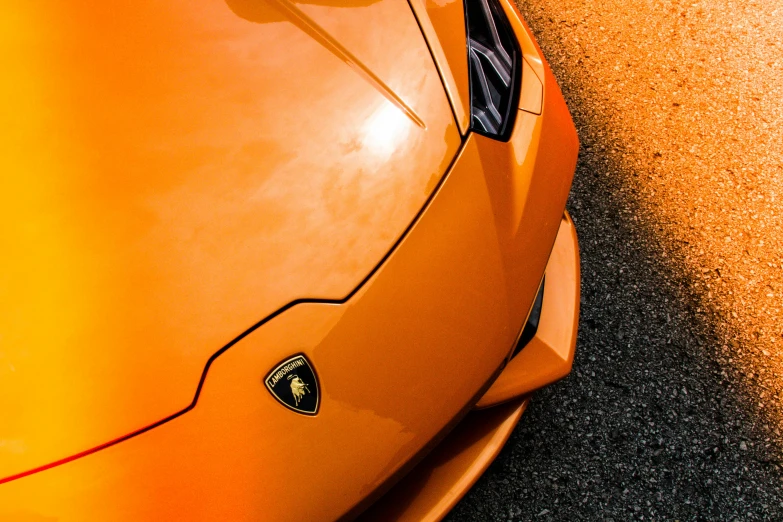 the top of an orange sports car parked on the road