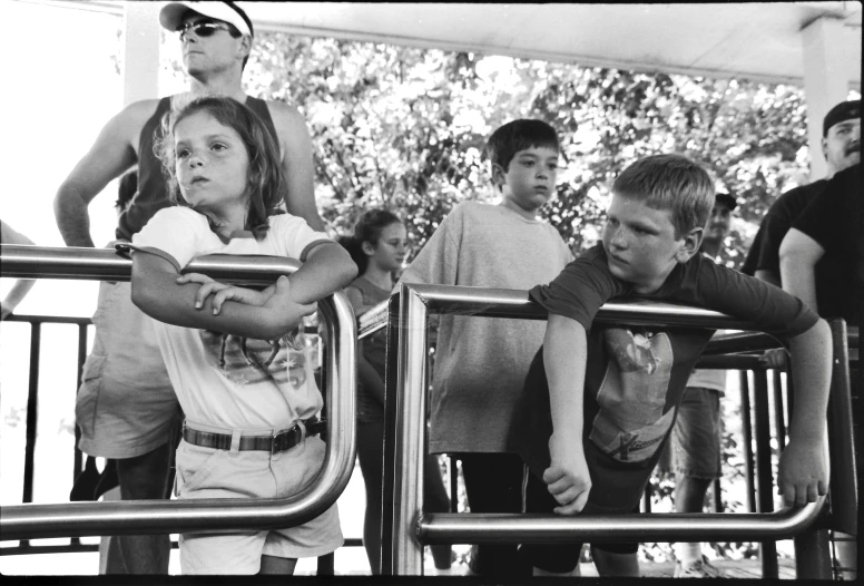 a little girl sitting in a chair looking at people