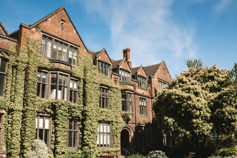 an old building covered with green plants on a sunny day