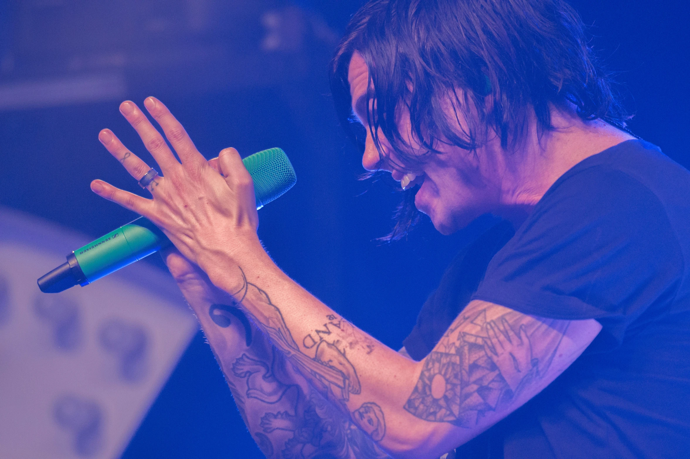 a man singing into a green microphone in front of a crowd