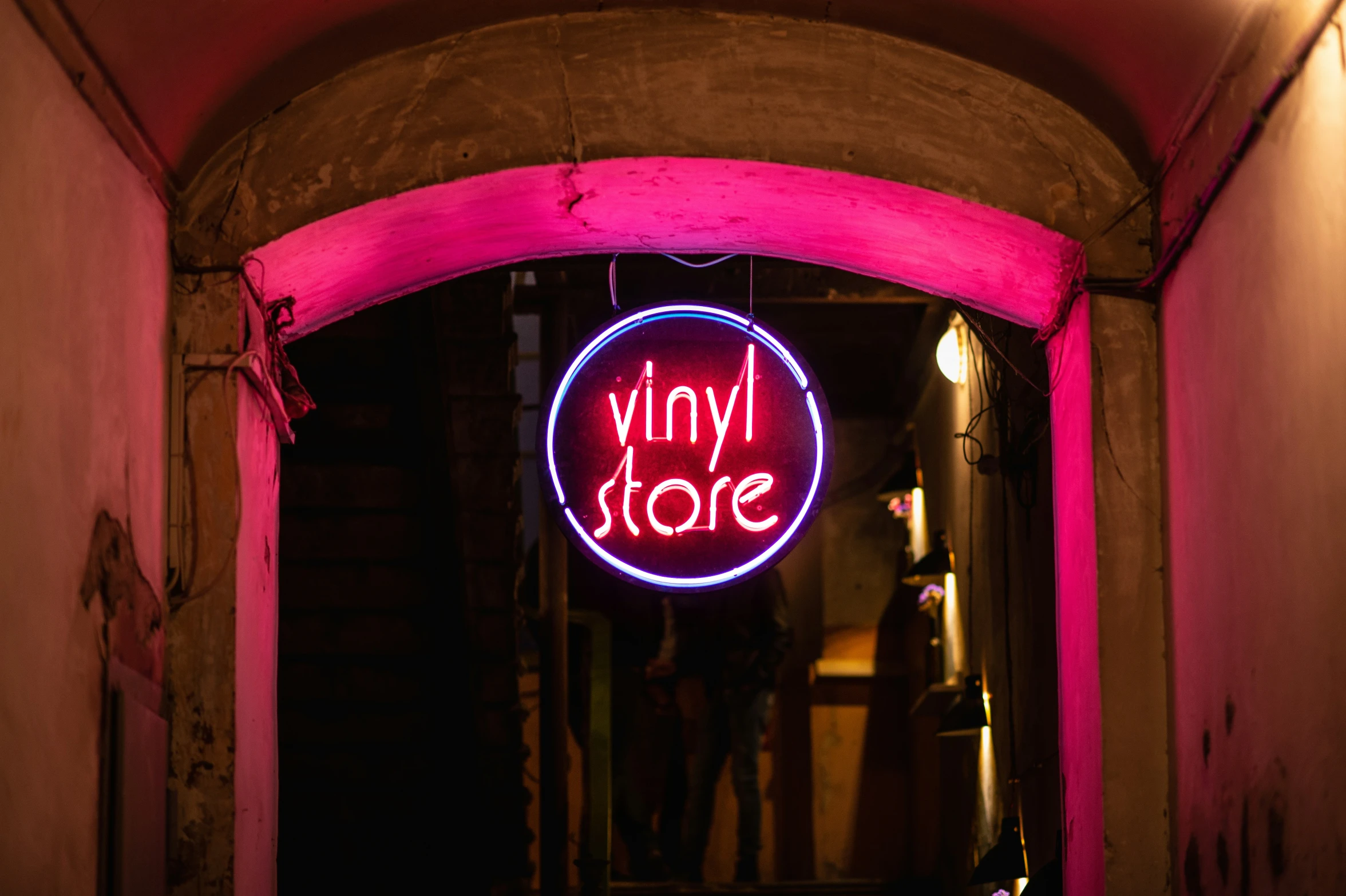 a man standing in a doorway holding up a large neon sign