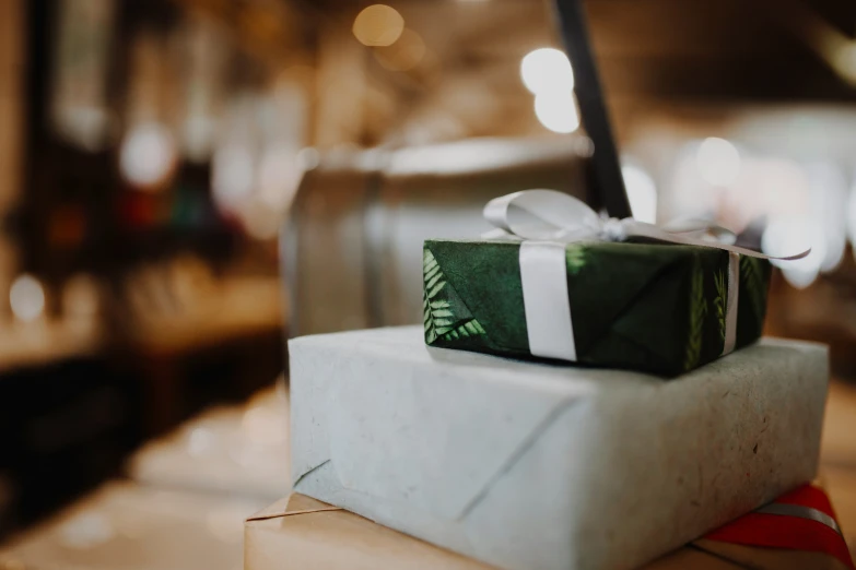 the small present box is tied up on top of a white box