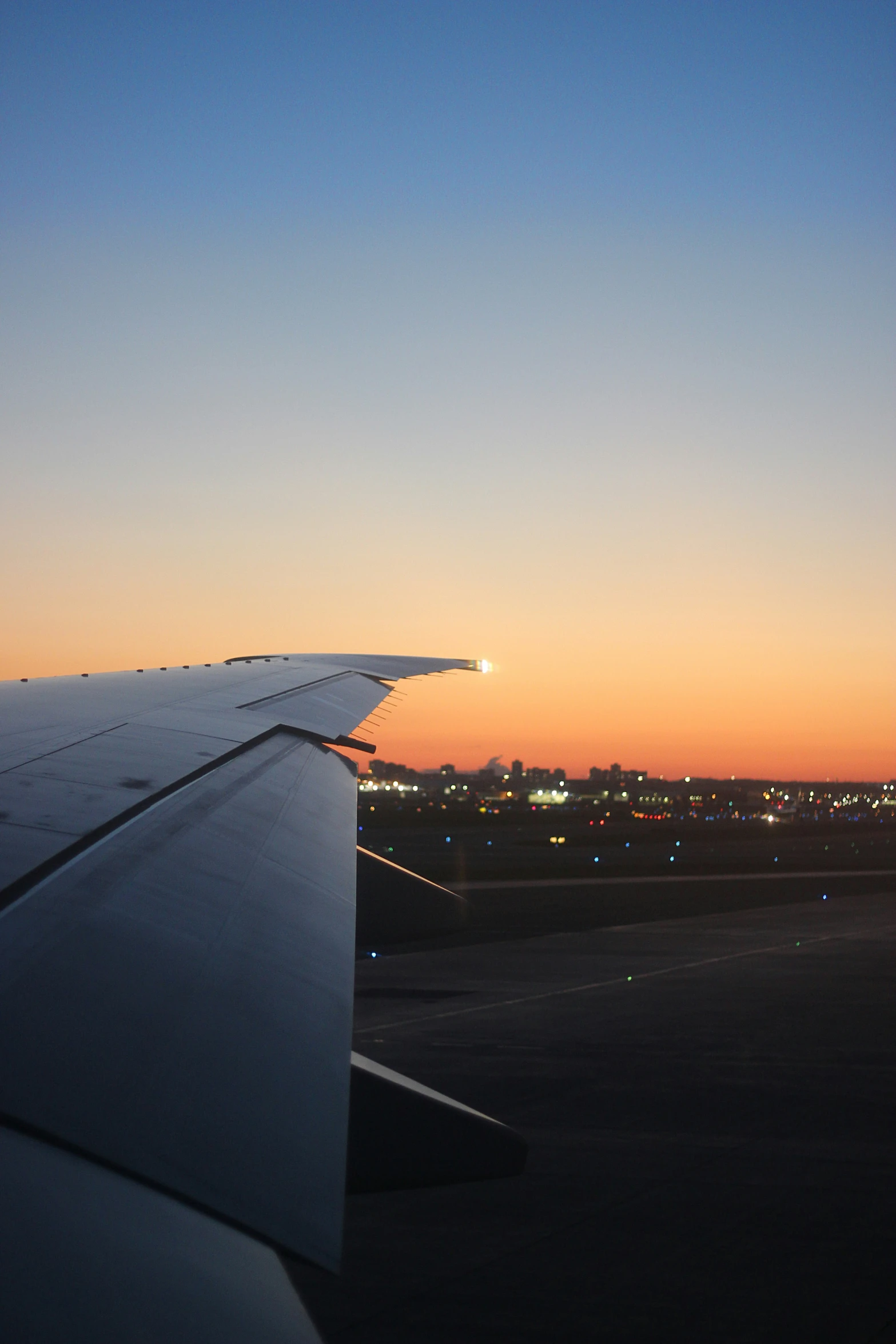 airplane wing on a runway with the sunset