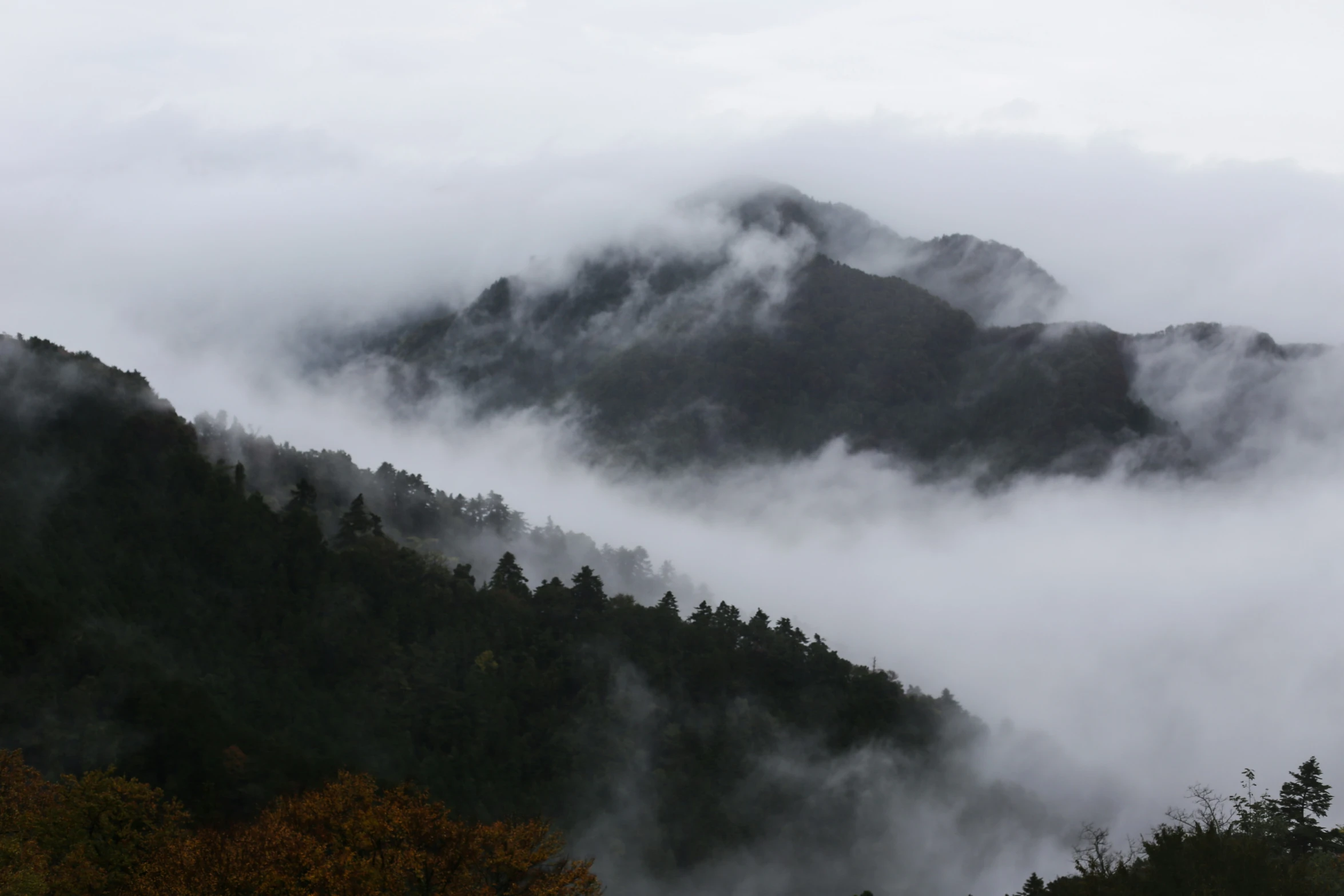 a mountain with fog rising up from the ground