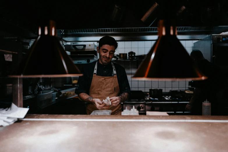 a chef is holding his dishes with other cooks standing in the background