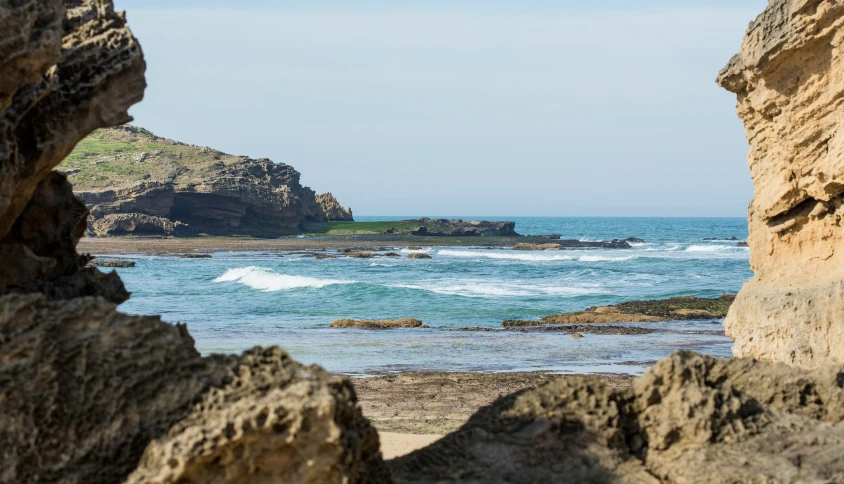 a large rock is shown near the beach