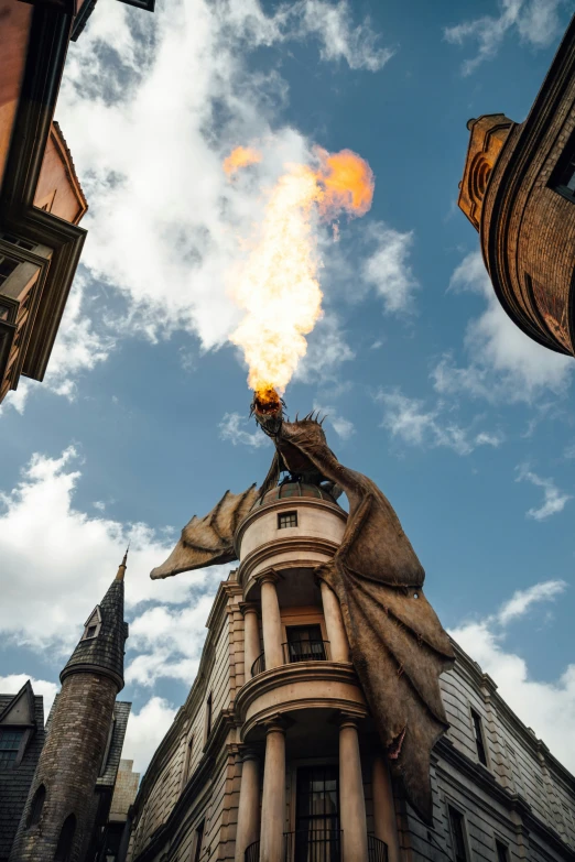 a dragon sits atop a spire with clouds above