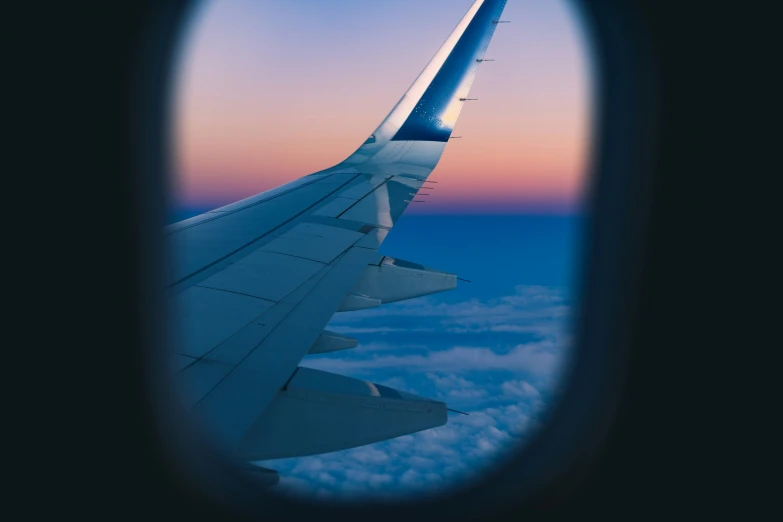 wing view in the window of an airplane with clouds