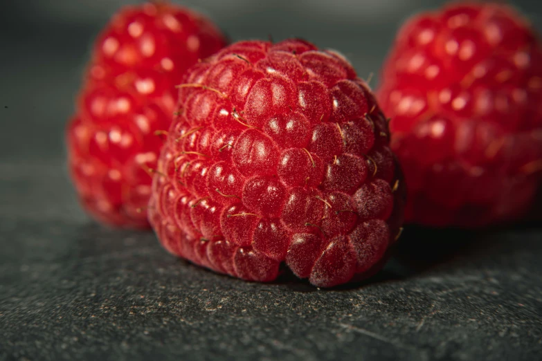 the three red fruits are lined up on the counter