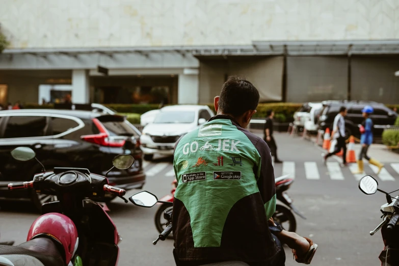 a man is walking on the street on his mopeds