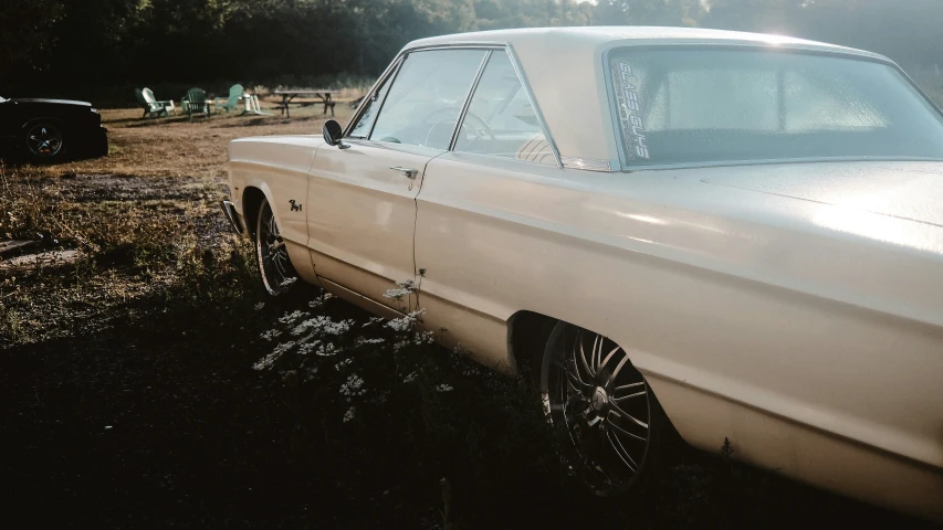 an older white car sits near a beach