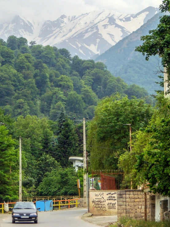 a car drives along a paved road near a gate