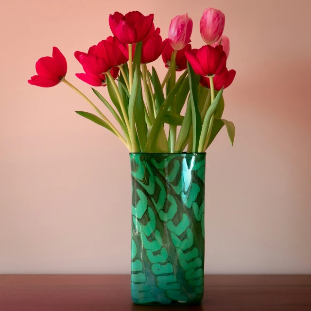 many red flowers in a vase on a brown table