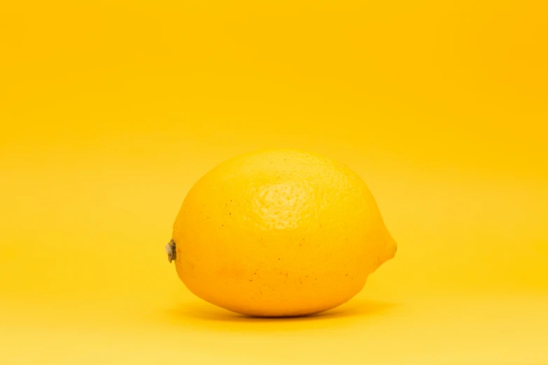 a close up of an orange on a yellow background