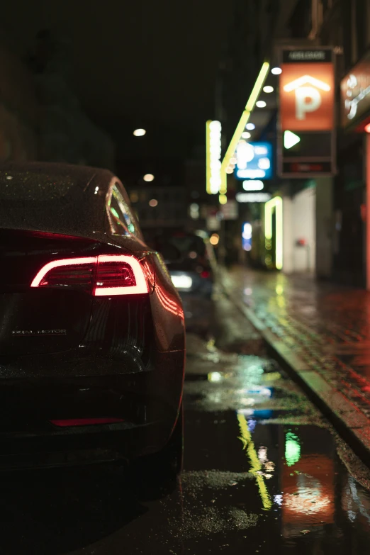 a line of cars parked on the street in the rain