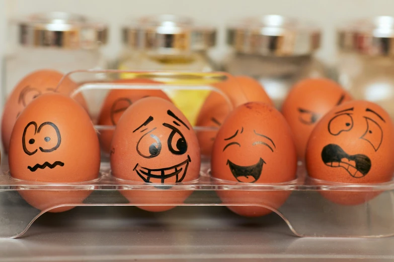 a tray with some eggs with drawn faces