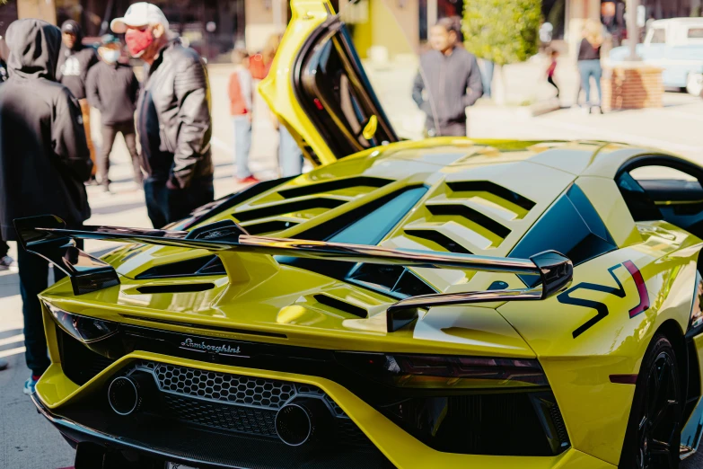 the hood of a yellow sport car with stripes on it