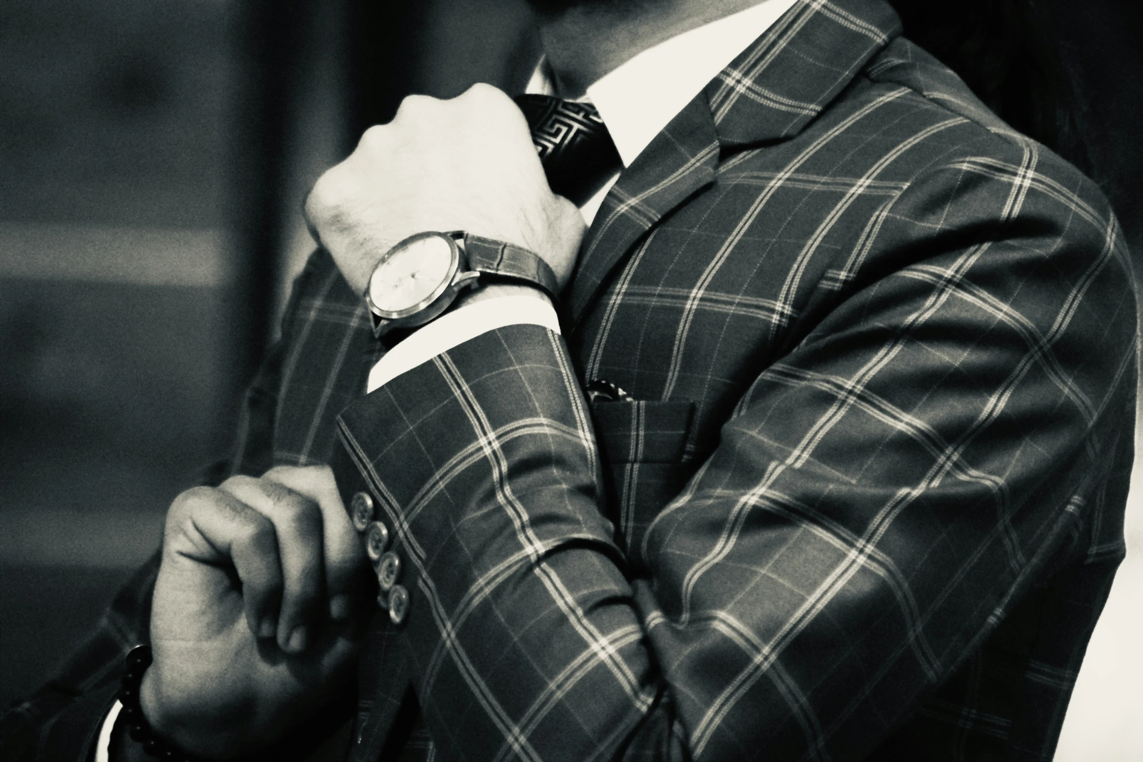 a man in a suit jacket and watch poses for a po