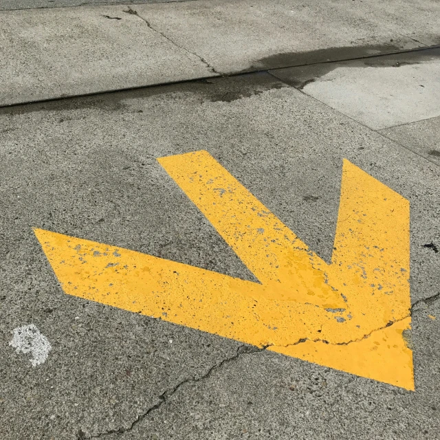 an arrow painted on the ground on a sidewalk