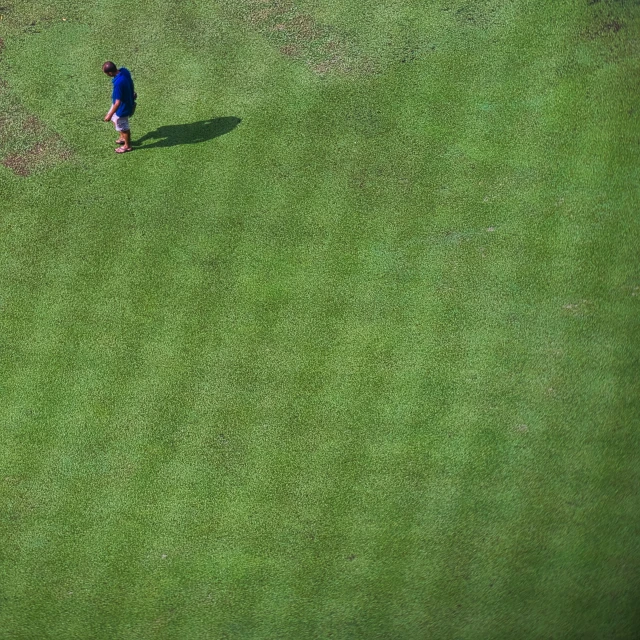 an aerial view of a man in the middle of a field