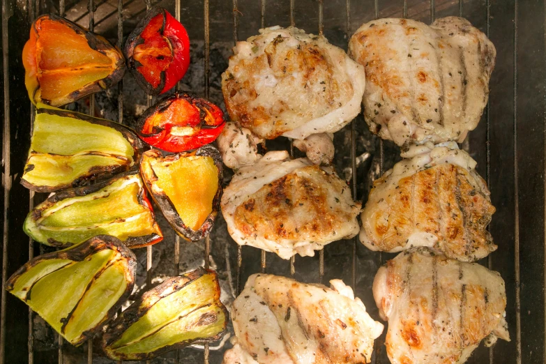 chicken and vegetables are cooking on a grill