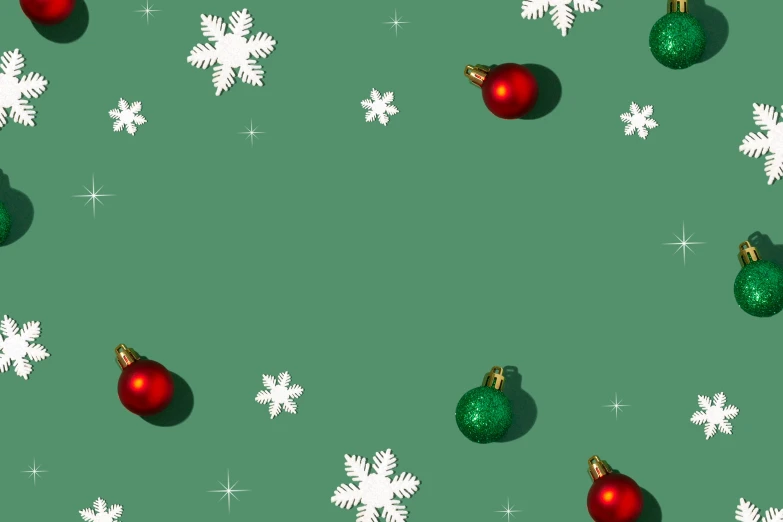 a red and green christmas ball next to snowflakes