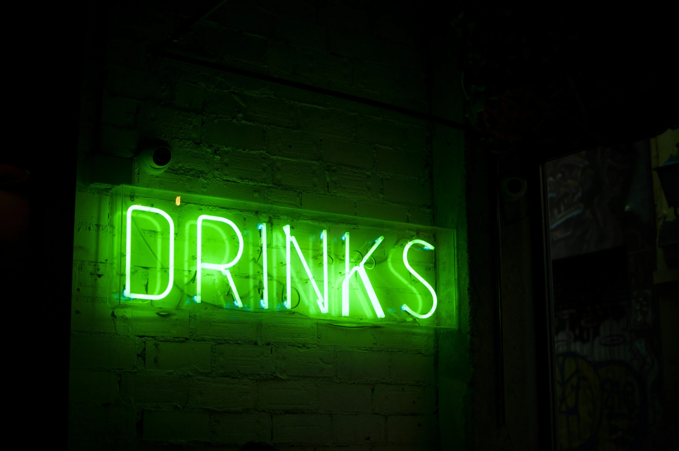 green neon sign lit up on the side of a building