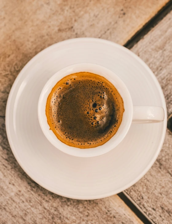 a cup of coffee on a wooden table