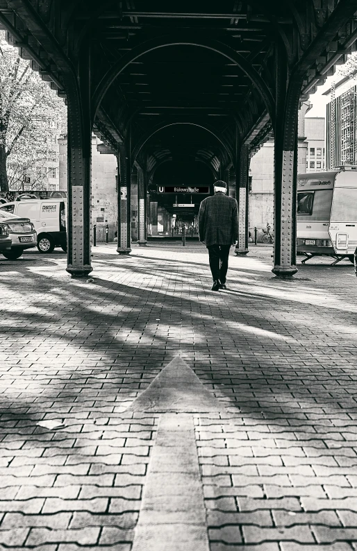 a black and white pograph of people walking on a brick street