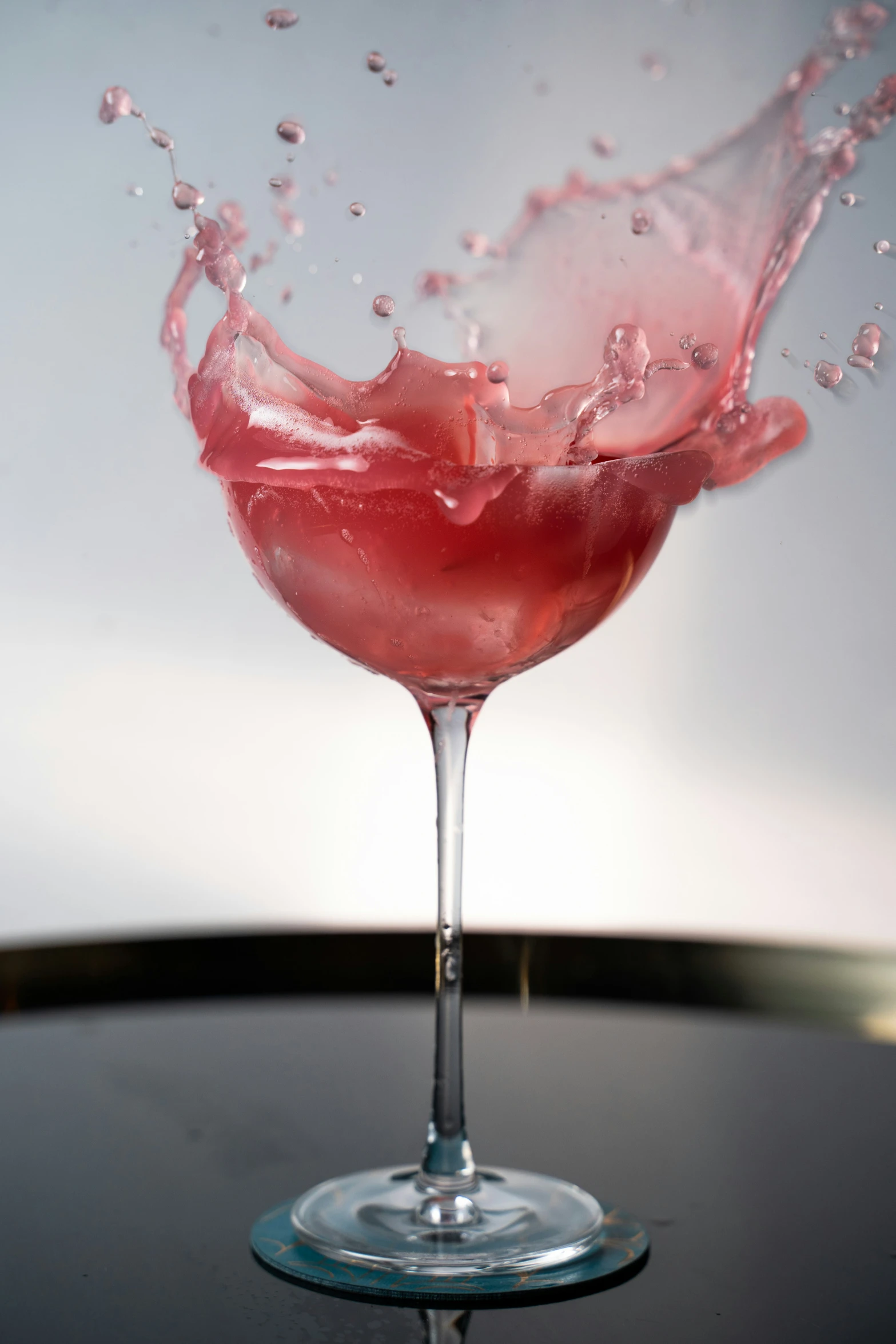 a pink liquid splashing into the cup