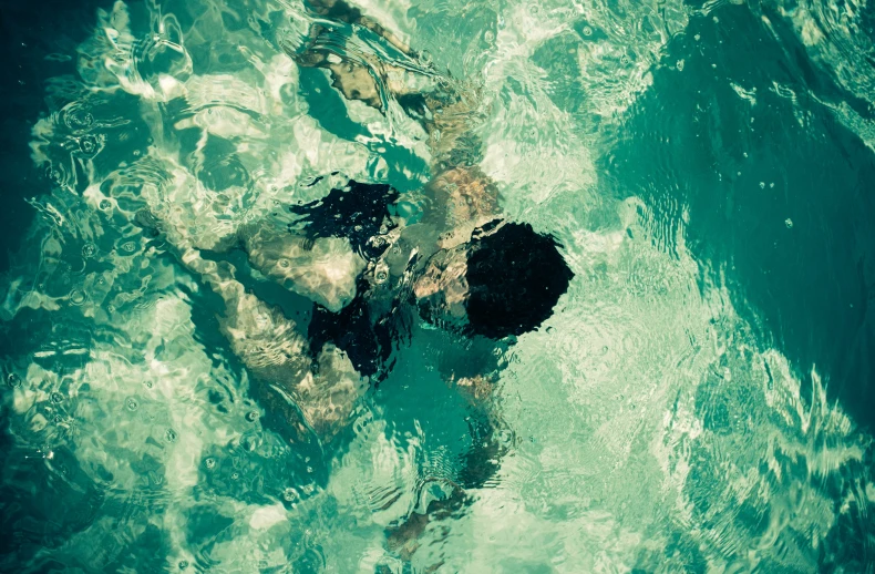 a person floating on their back in a swimming pool