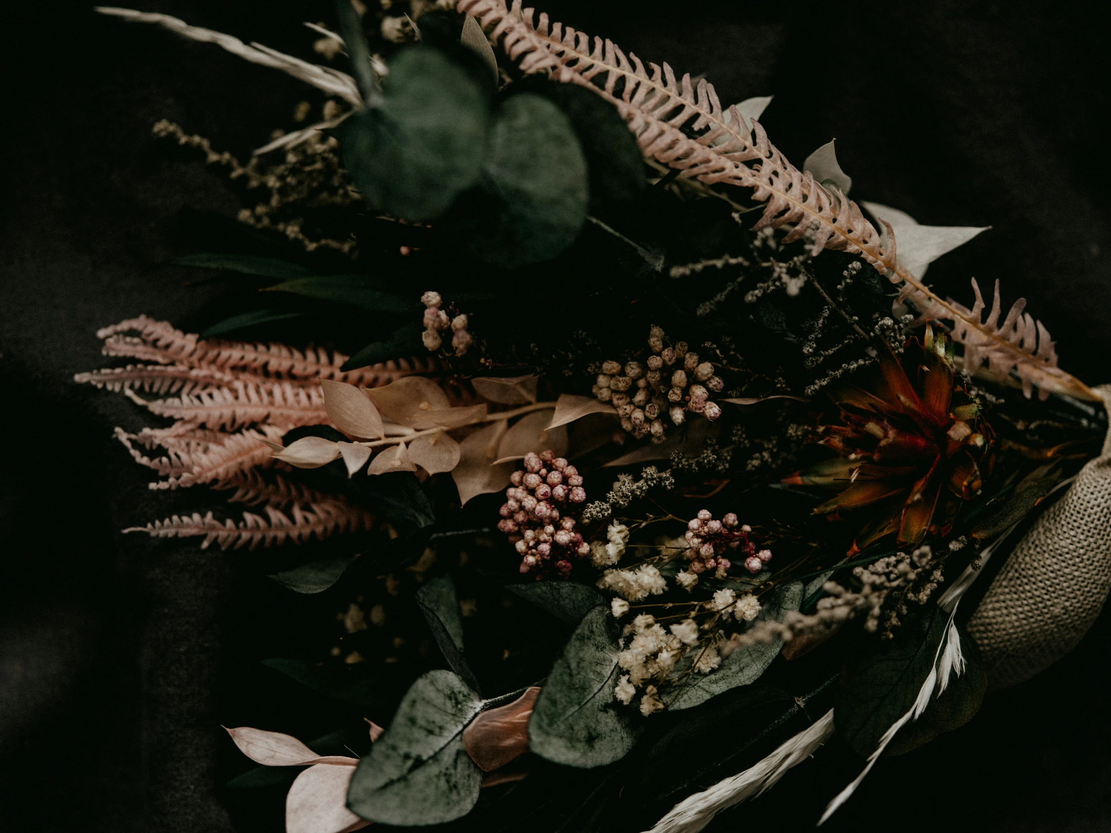 a bouquet of different kinds of flowers on a black background
