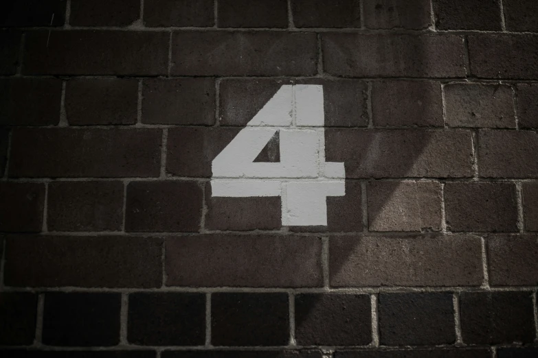 the number four painted on a brick wall