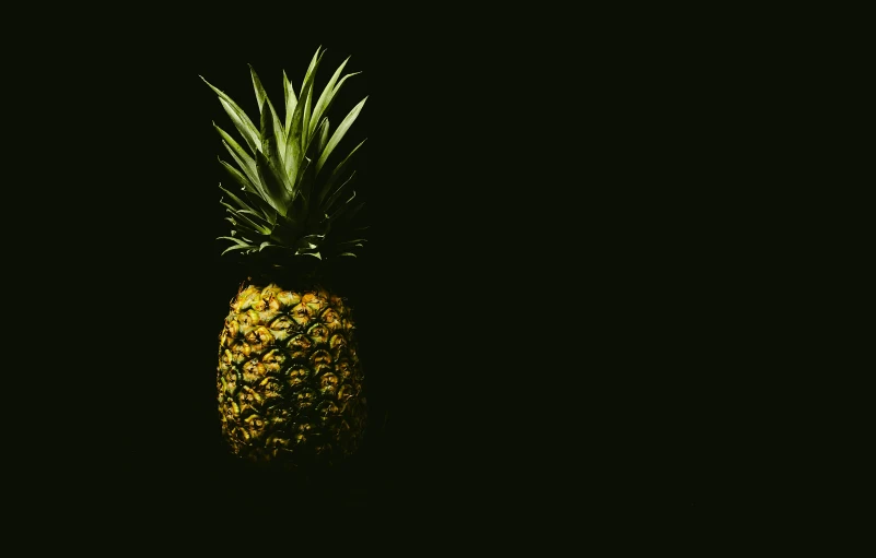 a black background with a pineapple sitting in the corner