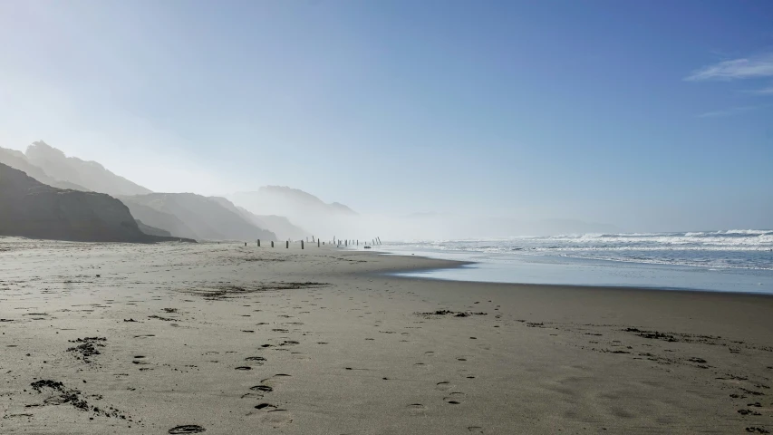 a misty beach is shown on the other side