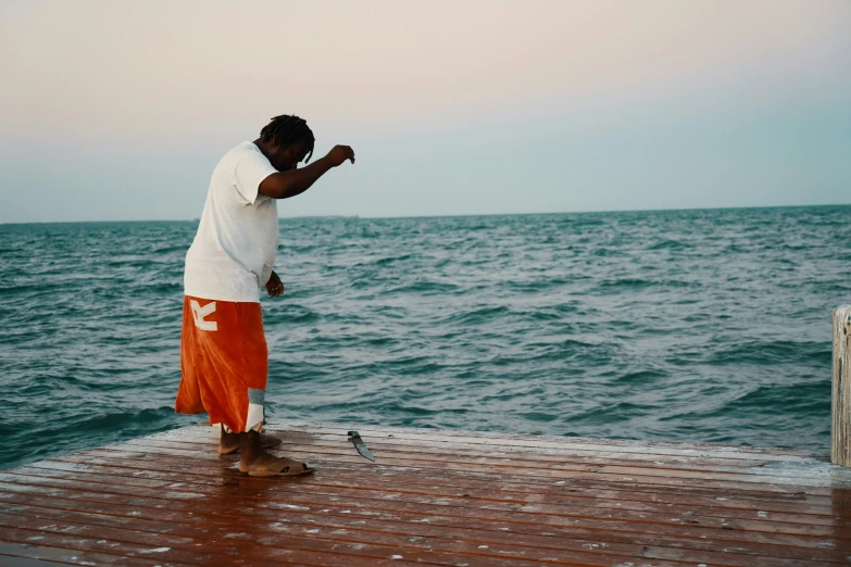 a man is standing on a dock and throwing a frisbee