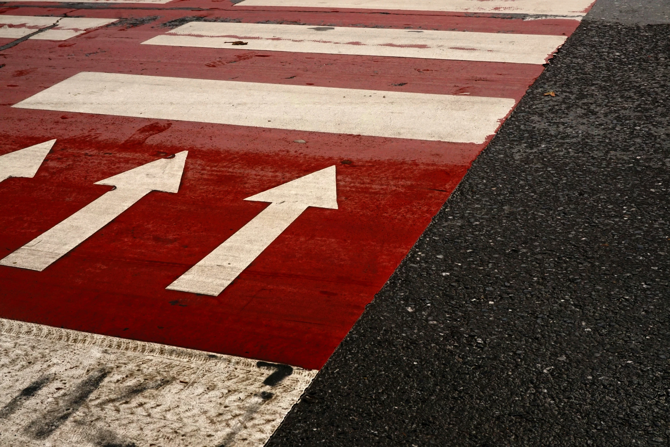 red, white, and black colored arrow on road