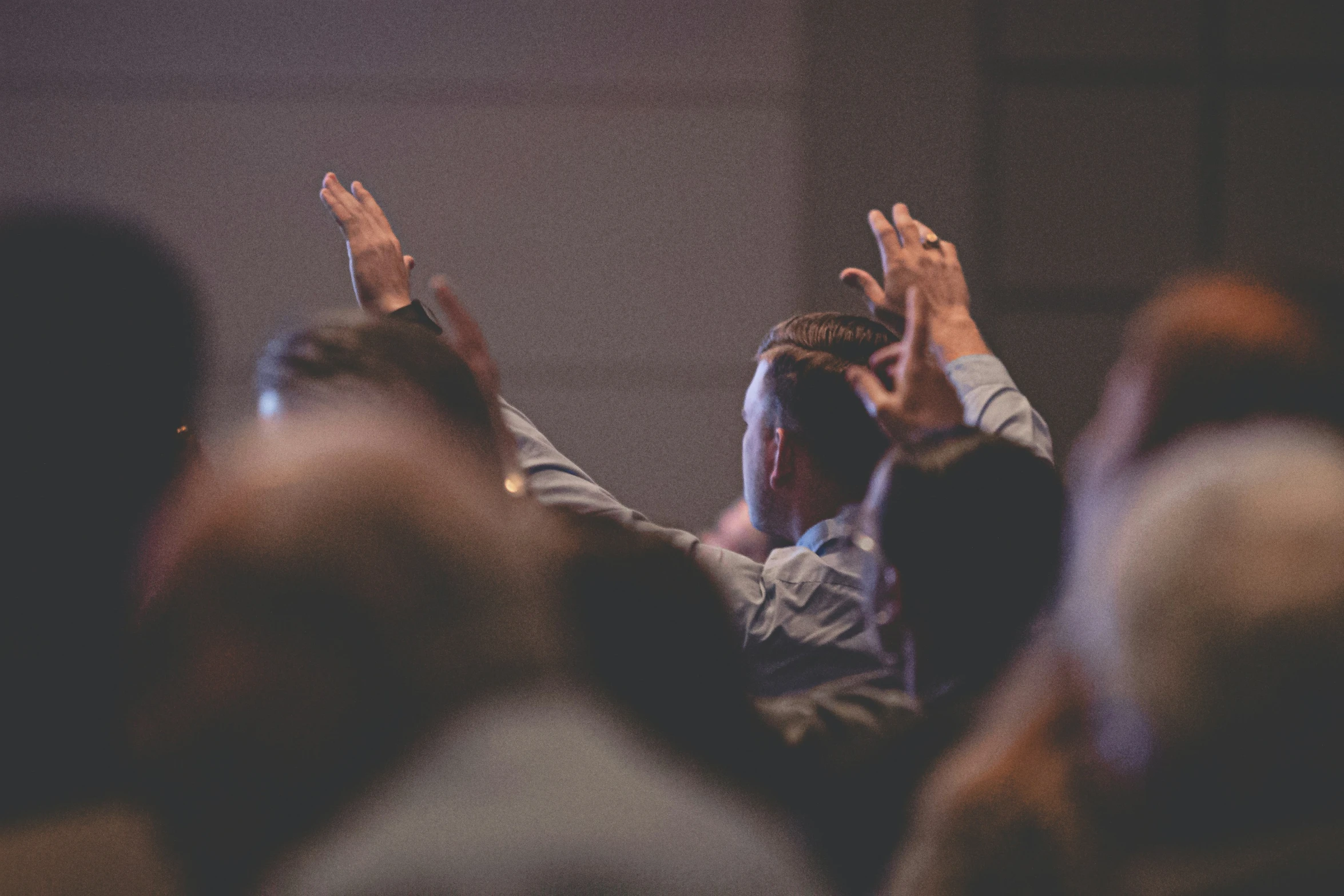 several people clapping and standing together, with the woman holding her hands up