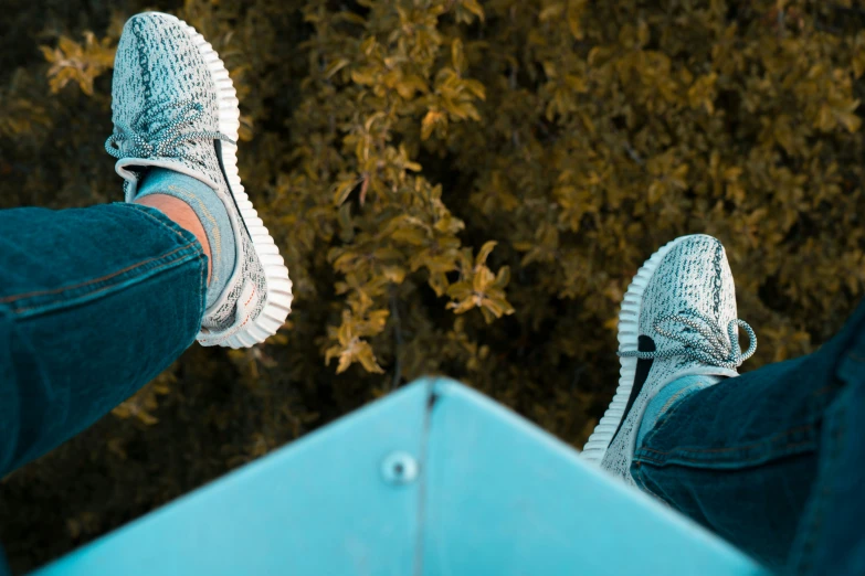 someone wearing sneakers with blue and white detailing sitting on a bench